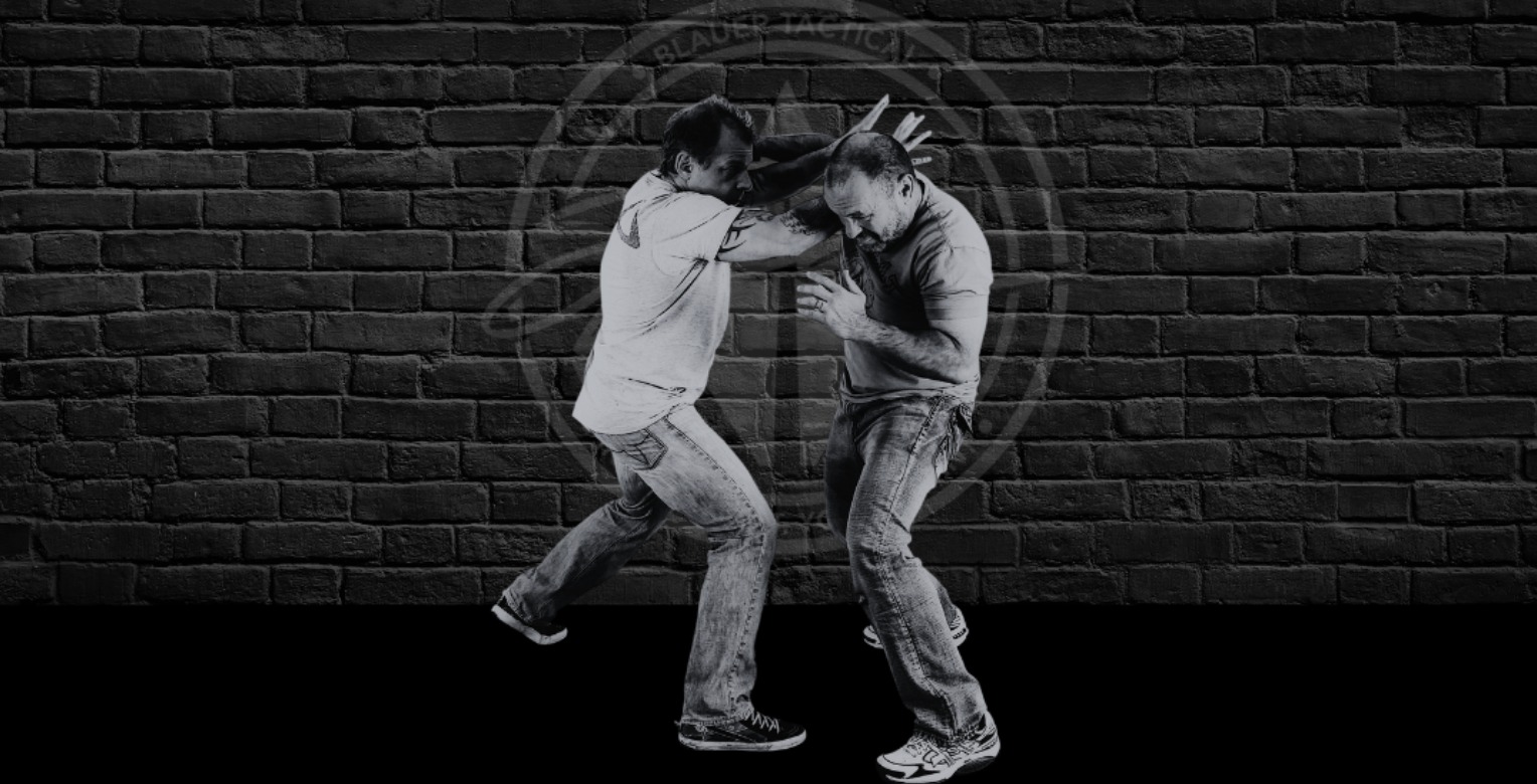 Coach Blauer countering a hook punch against a brick wall